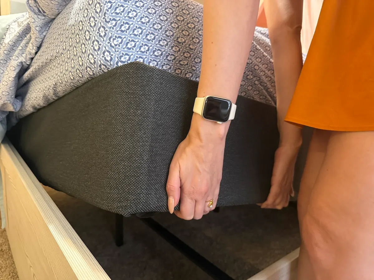 An image illustrating a woman lifting up a foundation for a mattress.