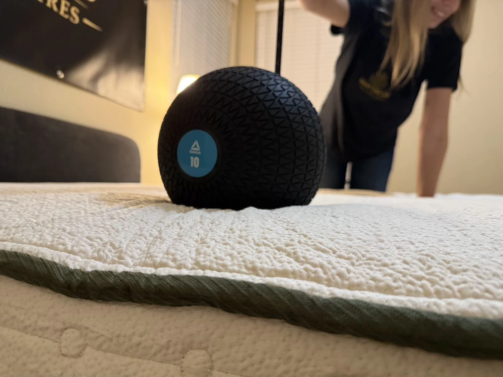 Ten-pound weighted ball testing motion isolation on the Avocado Green mattress
