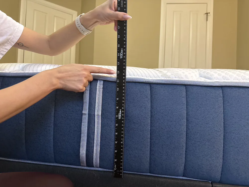 Measuring the 14-inch profile of the Bear Elite Hybrid mattress with a ruler