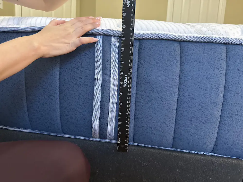 Measuring the 14 inch height of the Bear Elite Hybrid mattress with a ruler
