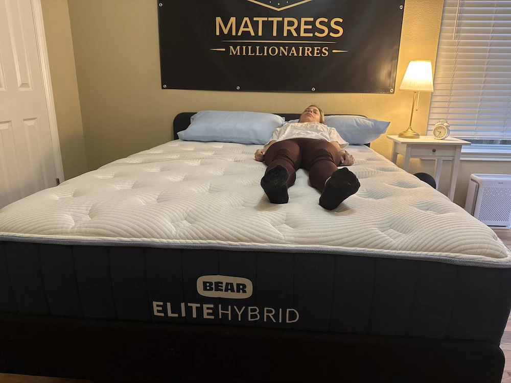 Tester lying on her back on a Bear Elite Hybrid mattress