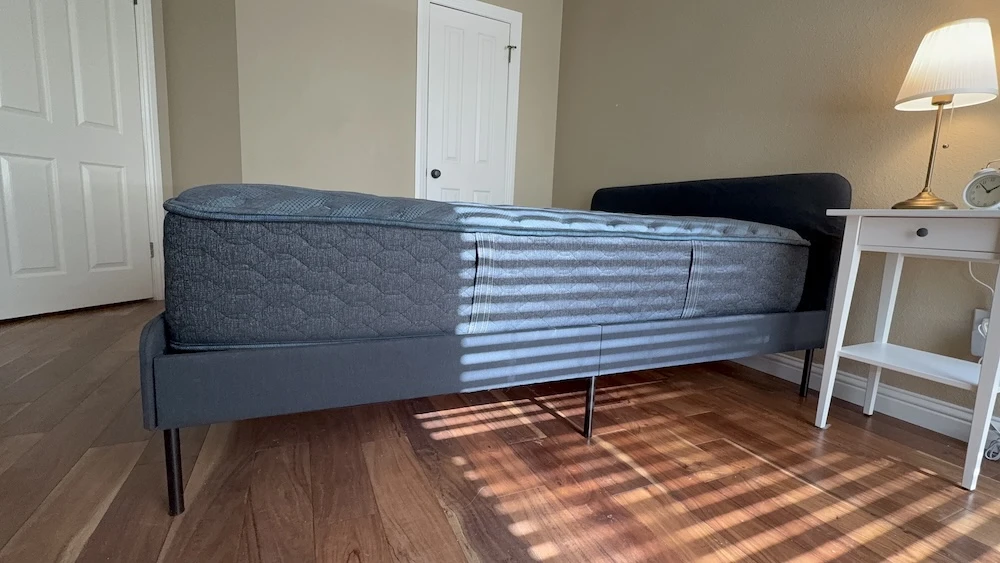 Side profile of the 12-inch Beautyrest Silver BRS900 mattress on a platform bed