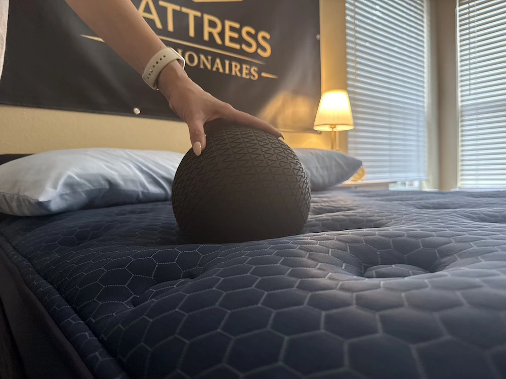 Weighted ball sinkage test on Brooklyn Bedding Signature Hybrid mattress showing depth of compression for heavier sleepers