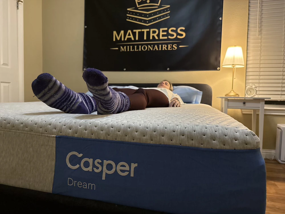 Tester lying on the DreamCloud Premier mattress to assess back sleeping support