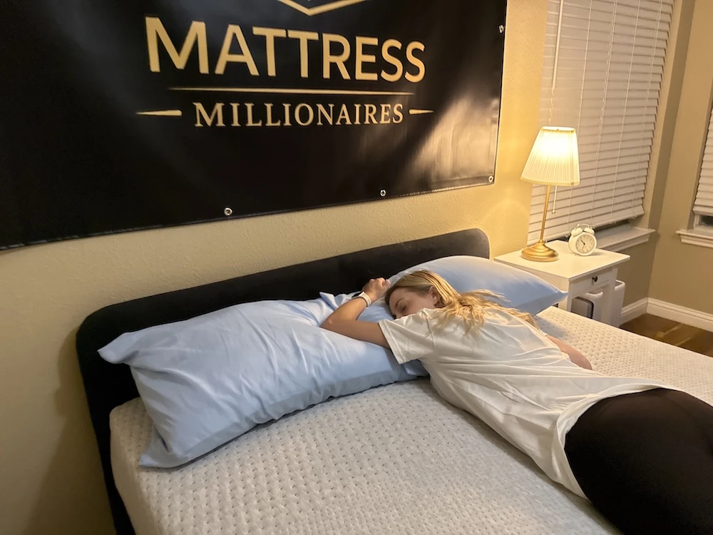 Lying on the Casper Dream mattress to test comfort and surface feel