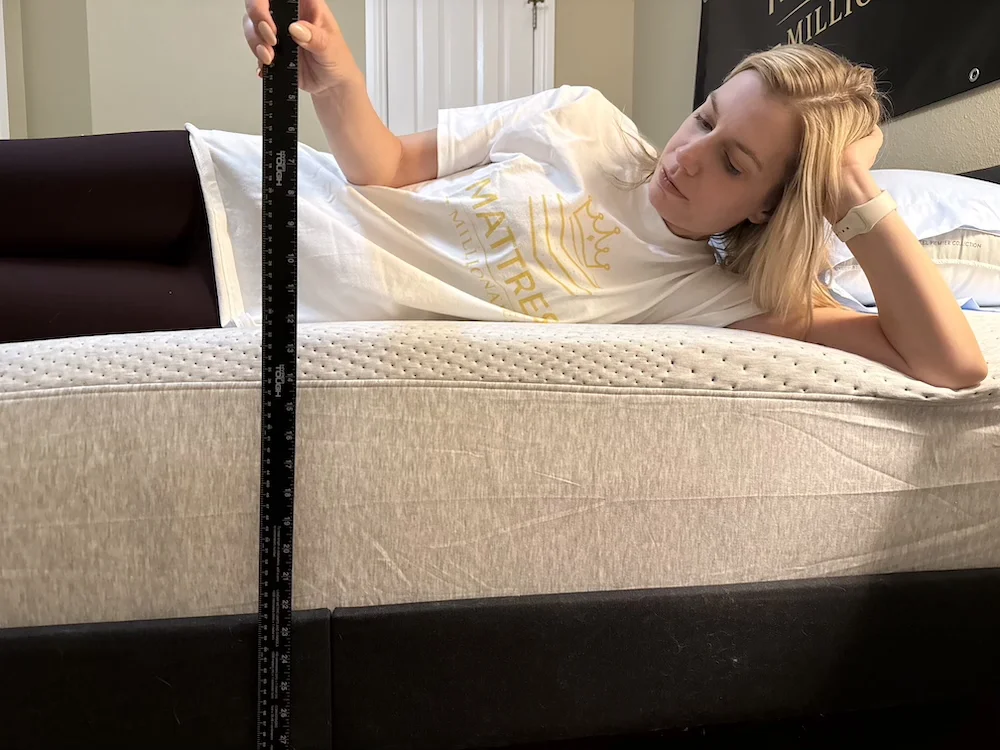 Side sleeping on the Casper Dream mattress while measuring sinkage depth