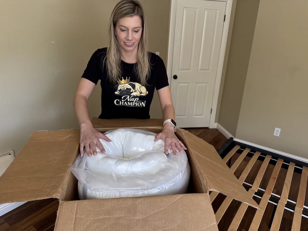 Tester removing the DLX Premier Hybrid queen-sized mattress from the box