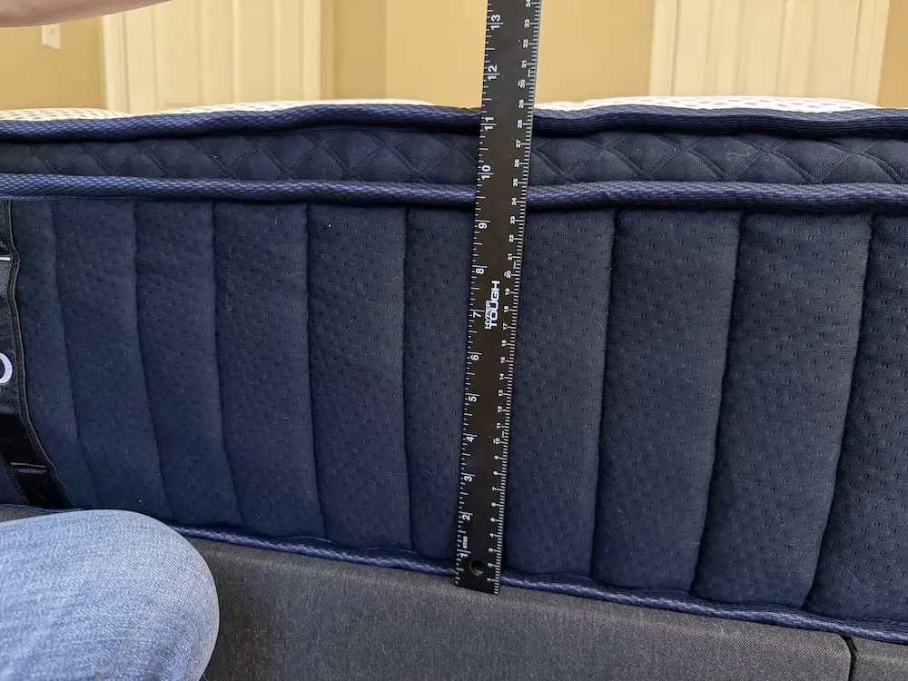 Measuring the full height of the DreamCloud Premier mattress with a ruler