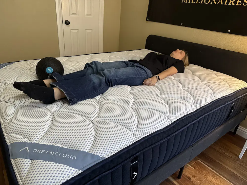 Back sleeping on DreamCloud Premier mattress showing lifted support from coils