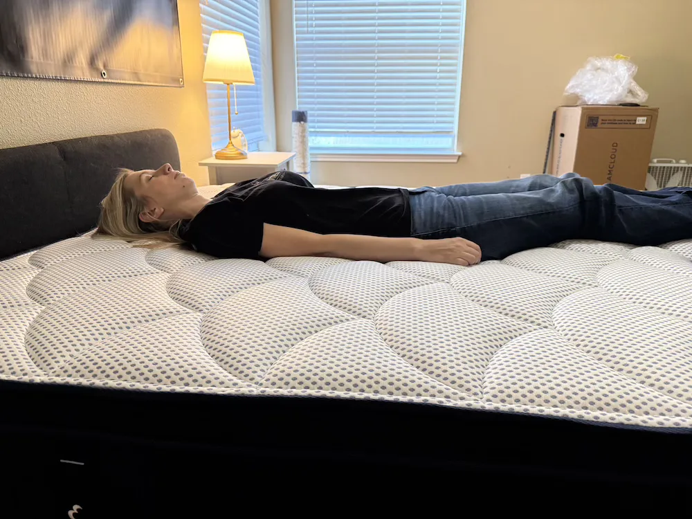Tester back sleeping on the DreamCloud Premier Hybrid mattress