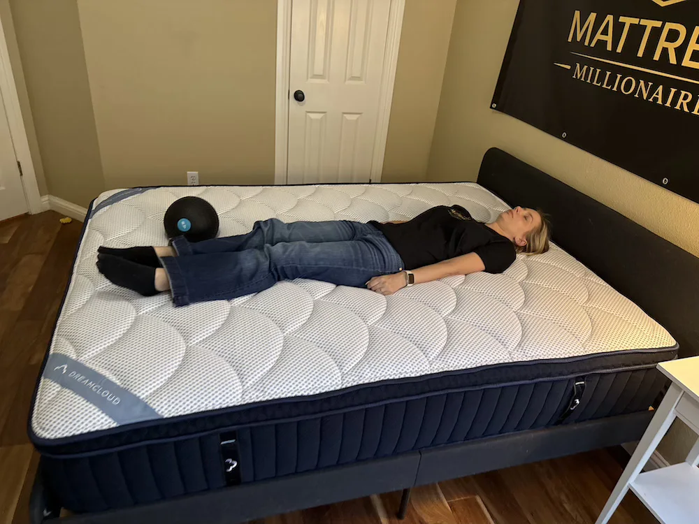 Tester lying on the DreamCloud Premier mattress to assess back sleeping support
