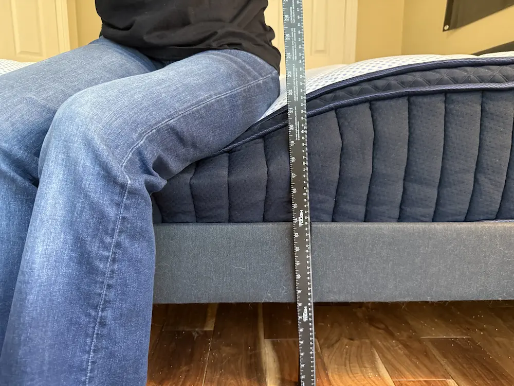 Sitting on edge of DreamCloud Premier mattress showing strong edge support