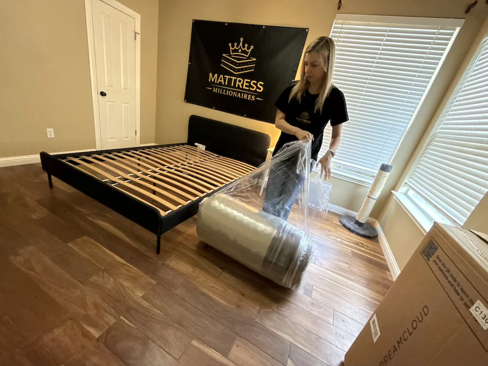Carrying the rolled DreamCloud Premier mattress in plastic wrap
