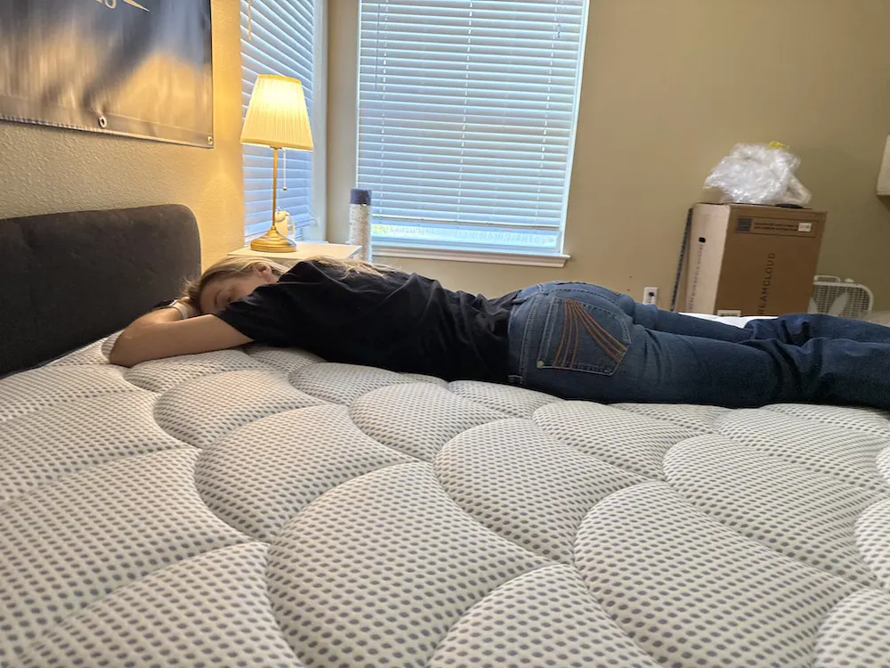 Mattress Millionaires tester lying on DreamCloud Premier Hybrid mattress in stomach sleeping position
