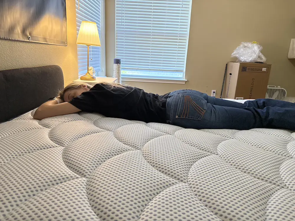Tester stomach sleeping on the DreamCloud Premier Hybrid mattress