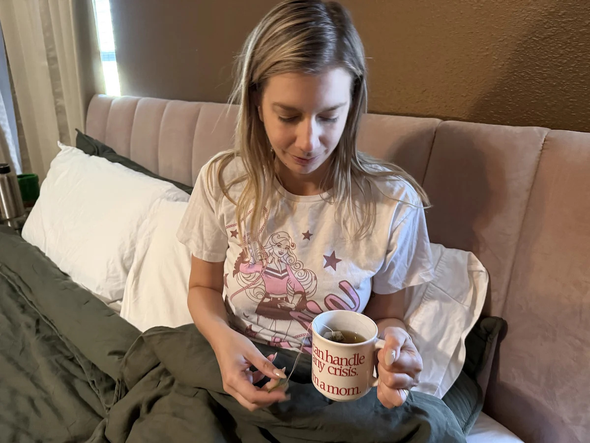 Woman drinking herbal tea in bed as part of a nighttime routine