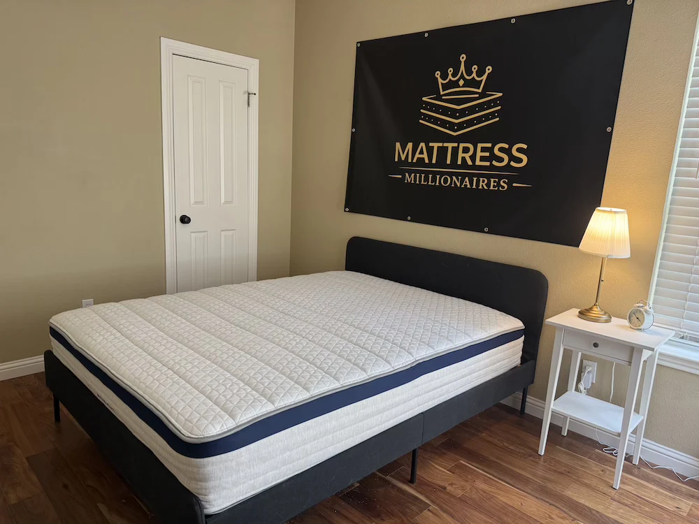 Full view of the Helix Midnight mattress on a bed frame in the Mattress Millionaires test room