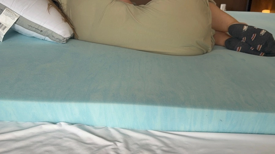 An image of a woman sleeping (side view), on a pillow and memory foam.