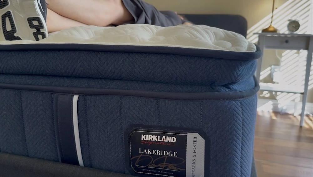 Tester lying near the edge of the Kirkland Lakeridge mattress to evaluate perimeter support