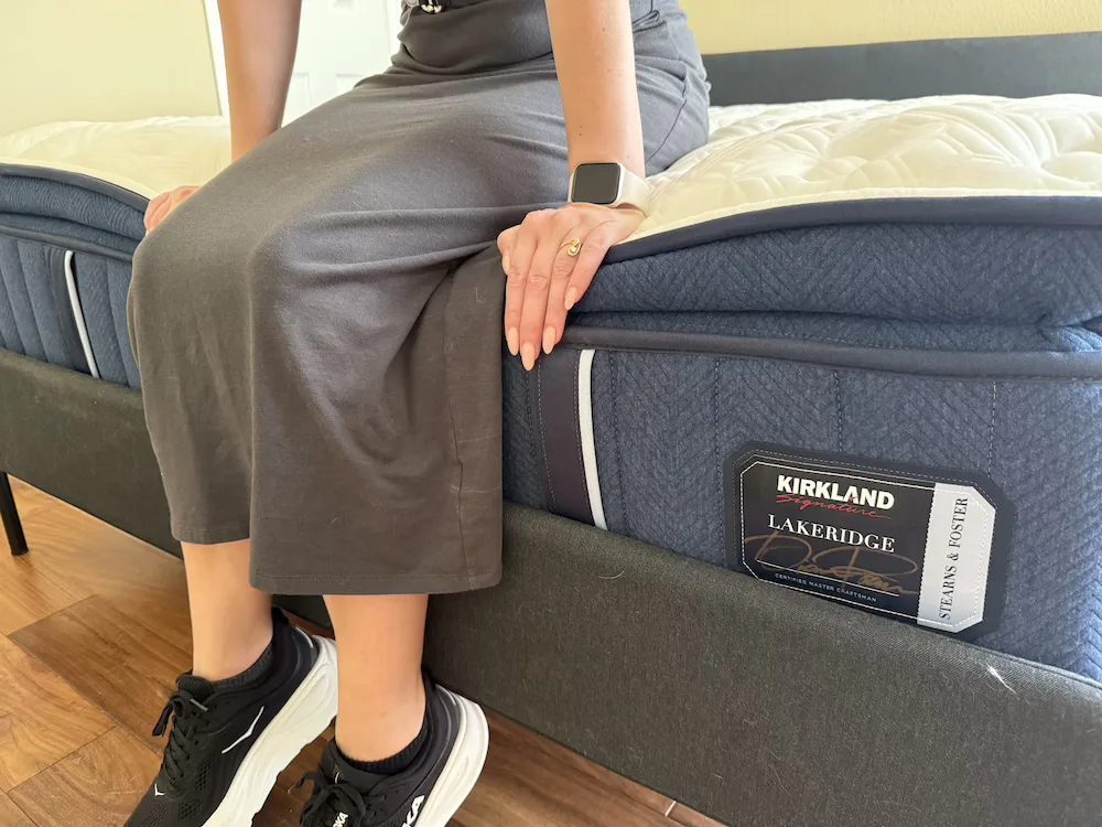 Tester sitting on the edge of the Kirkland Lakeridge mattress during edge support evaluation