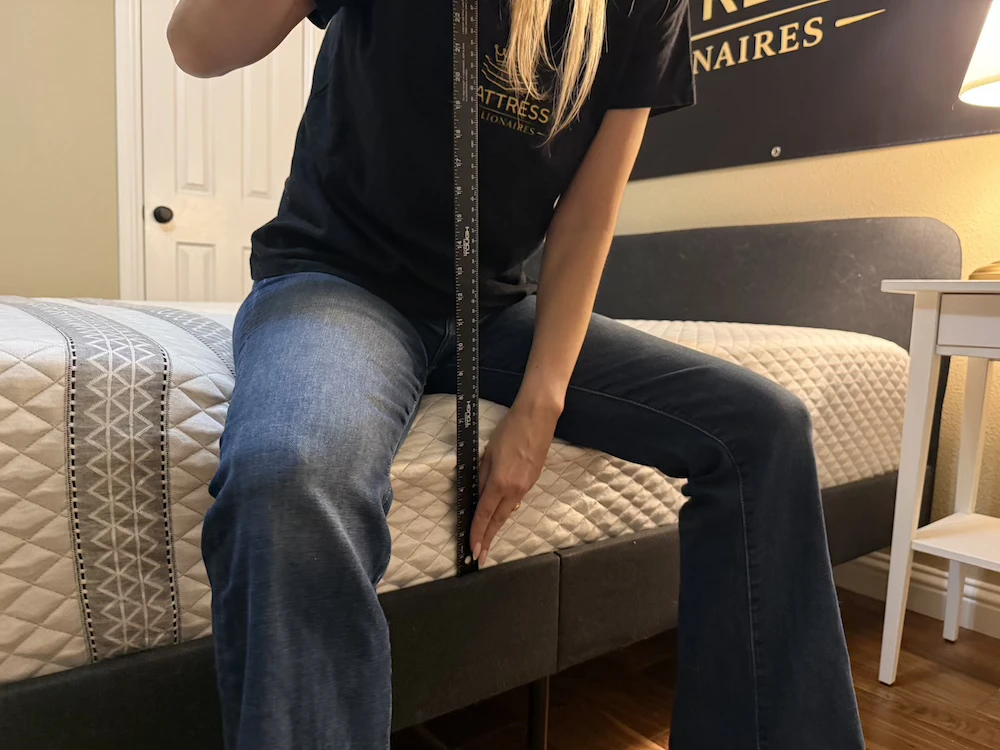 Tester measuring seated edge compression on the Leesa Sapira Hybrid mattress
