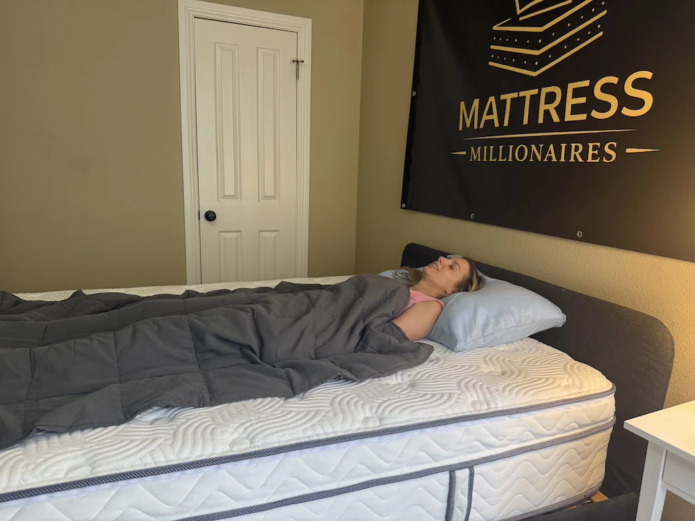 Woman lying on her back on a quilted mattress with her head on a blue pillow