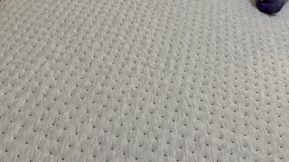 Close-up of textured mattress cover fabric with breathable perforation-style detailing