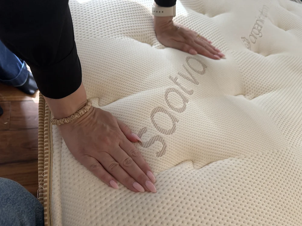 Hands pressing into mattress to demonstrate pressure relief and durability