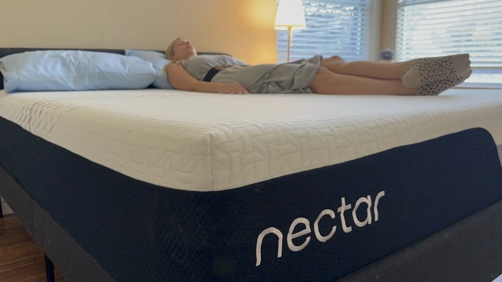 Person lying on Nectar Premier mattress on their back showing spinal alignment and foam contouring