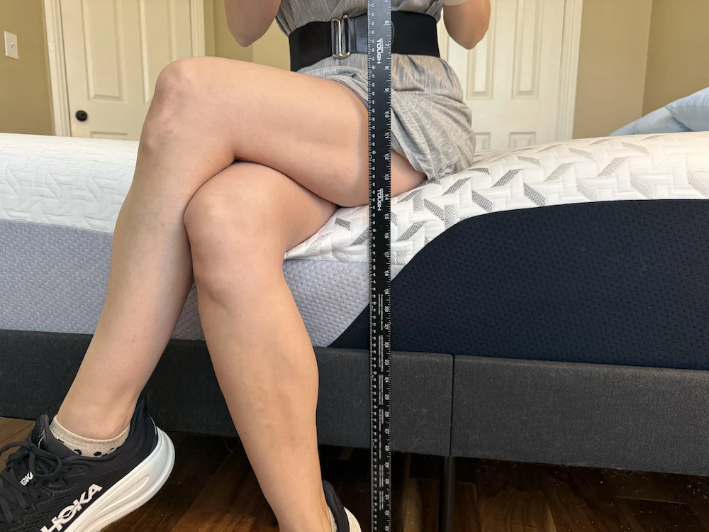 Sitting on the edge of Nectar Premier mattress showing edge support and sinkage