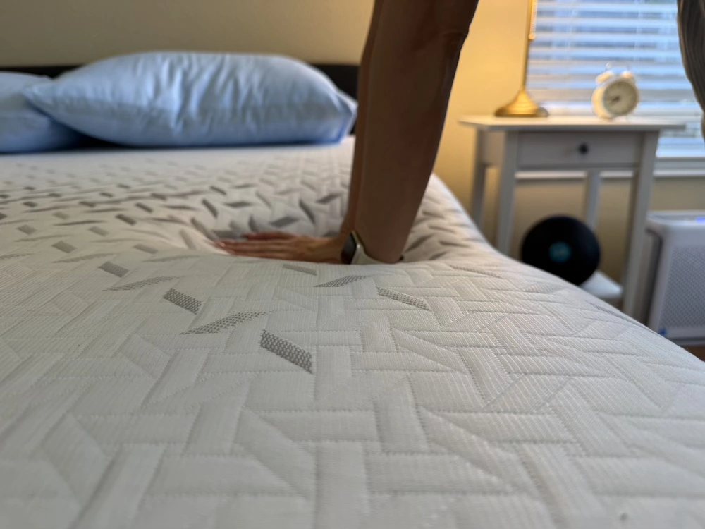 Hand pressing into Nectar Premier mattress showing foam response