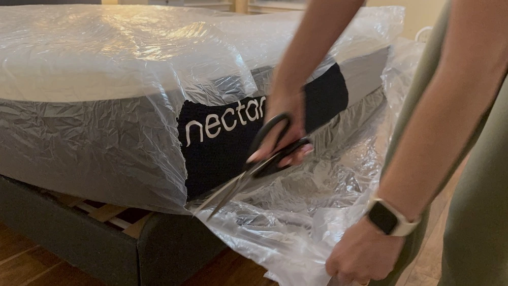 Cutting open plastic wrapping on Nectar Premier mattress during unboxing