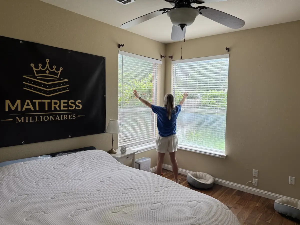 Person opening bedroom blinds to improve airflow and regulate bedroom temperature
