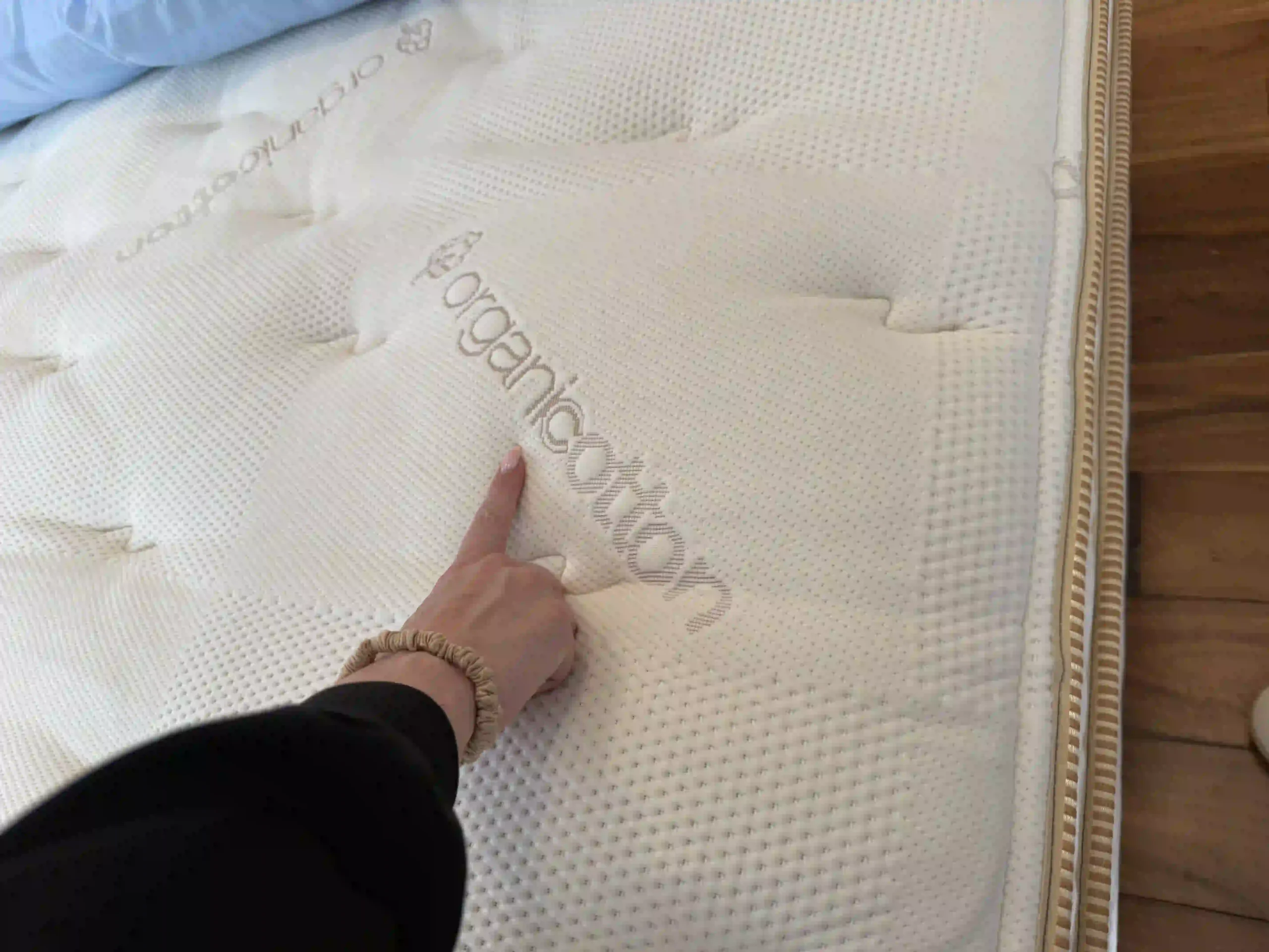 Hand pointing to an organic cotton label on a mattress cover