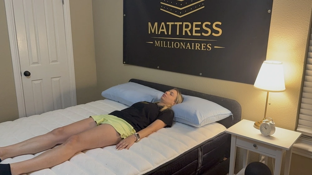 Mattress tester lying on her back on the Origin Adapt Hybrid during hands-on support testing