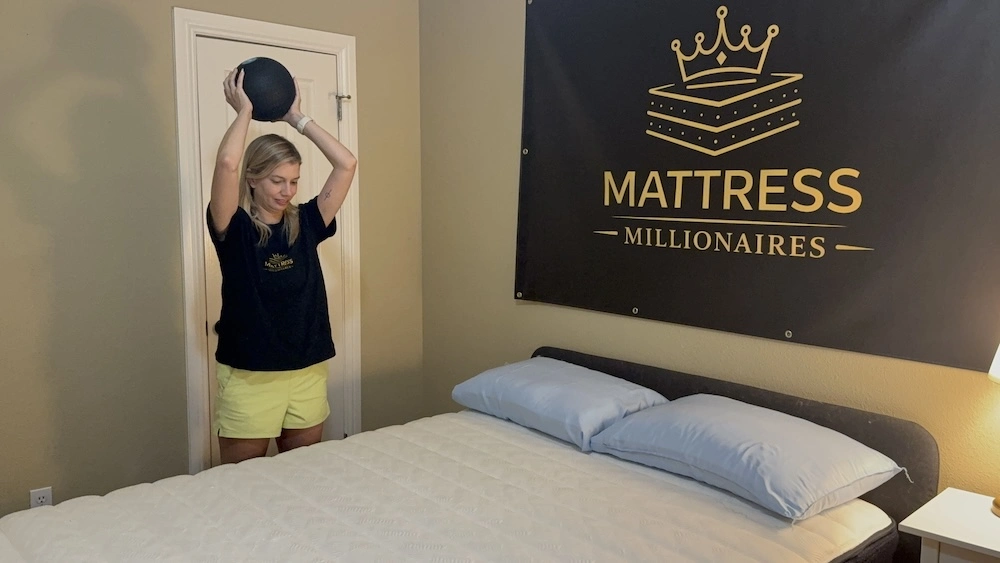 Tester performing a weighted ball-drop test on the Origin Adapt Hybrid mattress