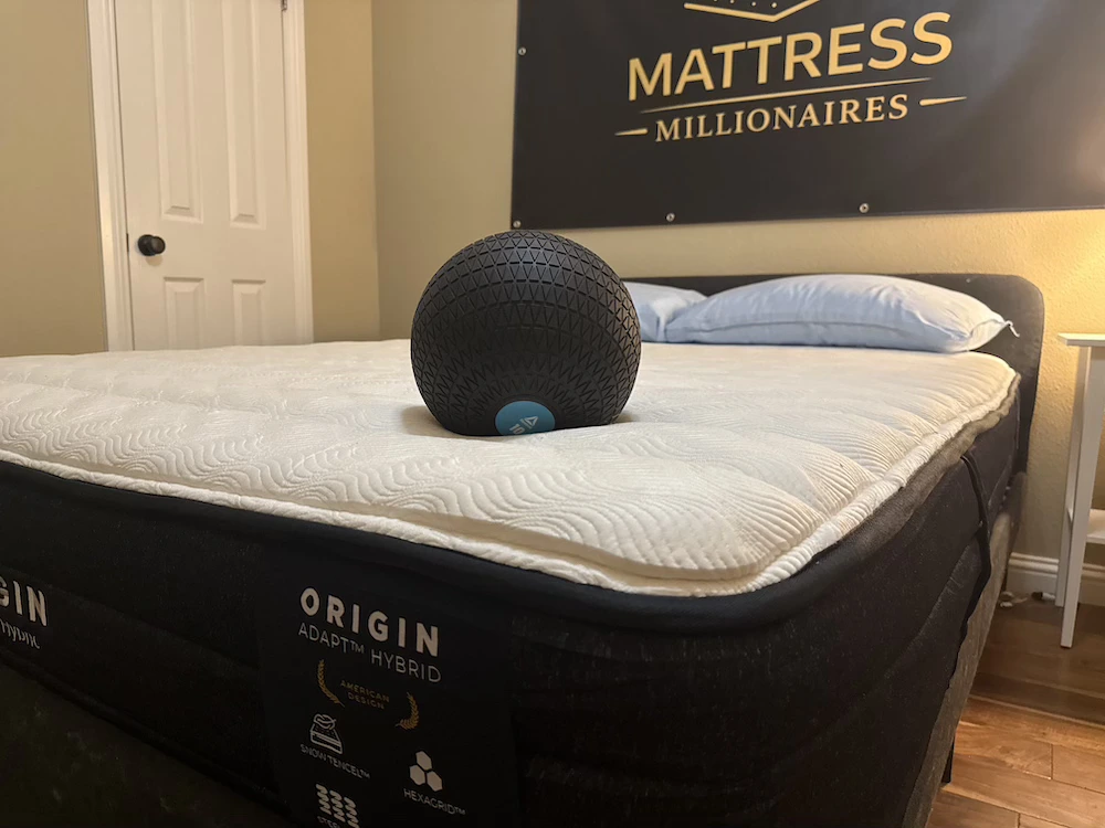 Weighted ball resting on the Origin Adapt Hybrid during mattress testing