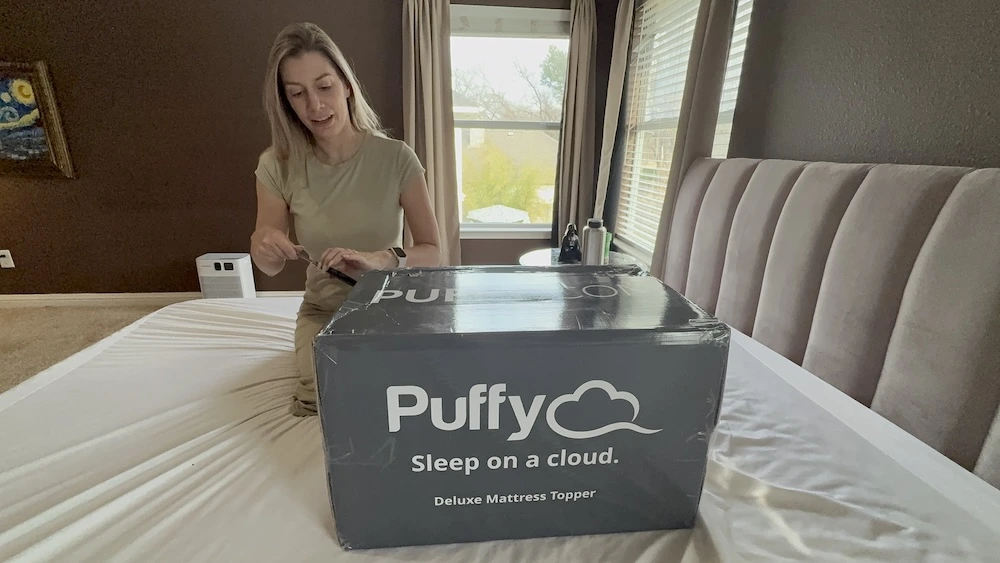 Puffy Deluxe Mattress Topper box during unboxing in our bedroom
