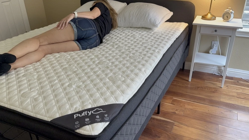Side sleeper lying on Puffy Lux Hybrid showing spinal alignment