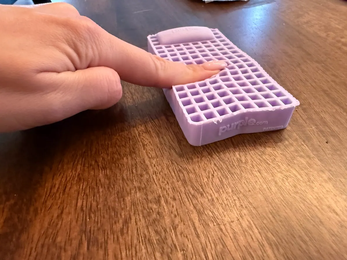 An image of a hand on the Purple gelflex grid, demonstrating the cooling design