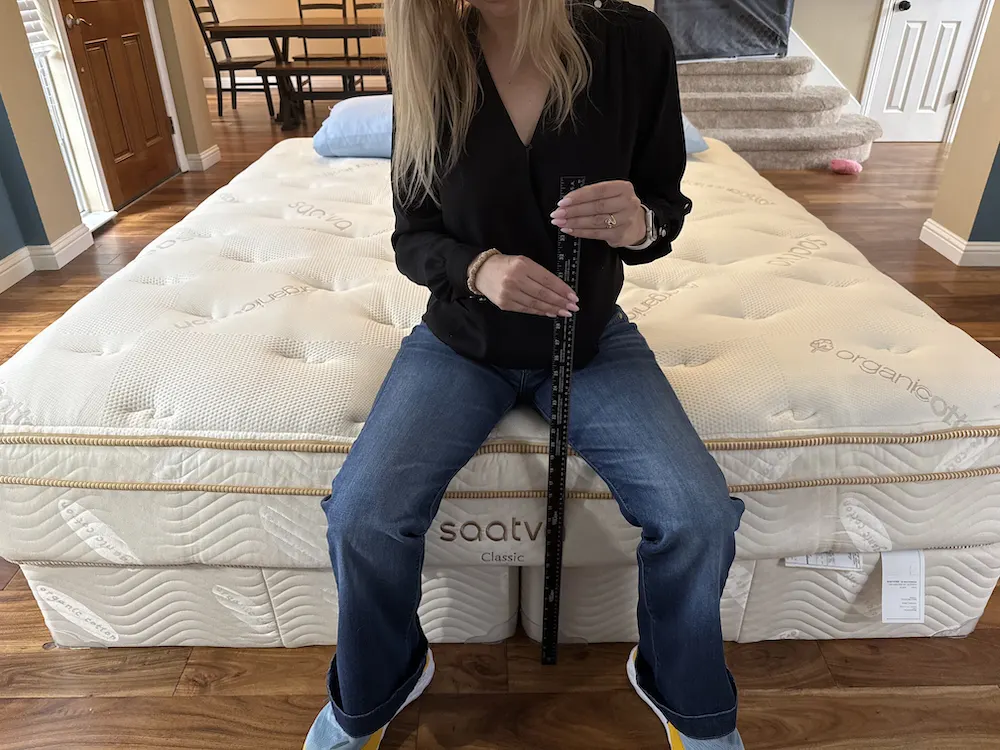 Sitting on edge of Saatva Classic mattress showing strong edge support