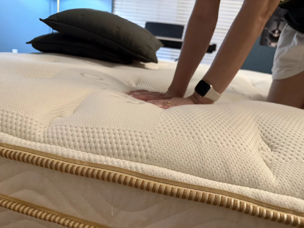 Hands testing Saatva Classic pillow-top cushioning