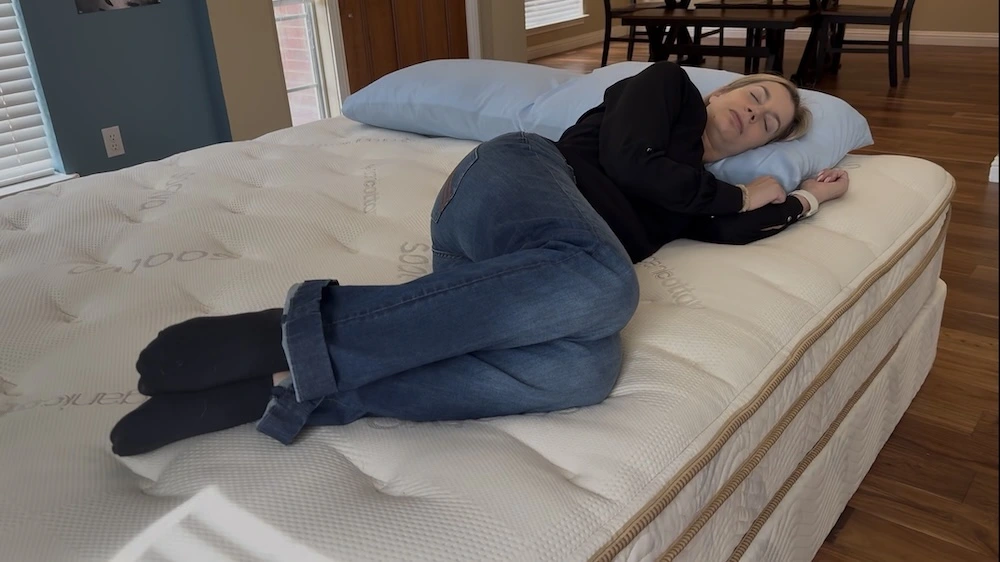 Side sleeper testing pressure relief on the Saatva Classic Luxury Firm mattress