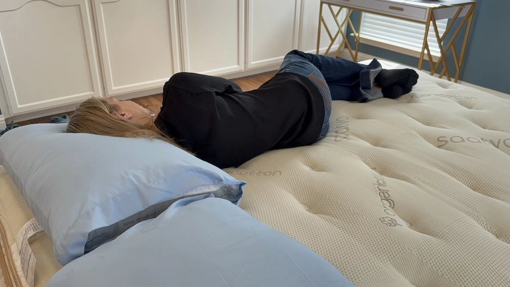Tester lying on her side on the Saatva Classic mattress to assess pressure relief for side sleepers