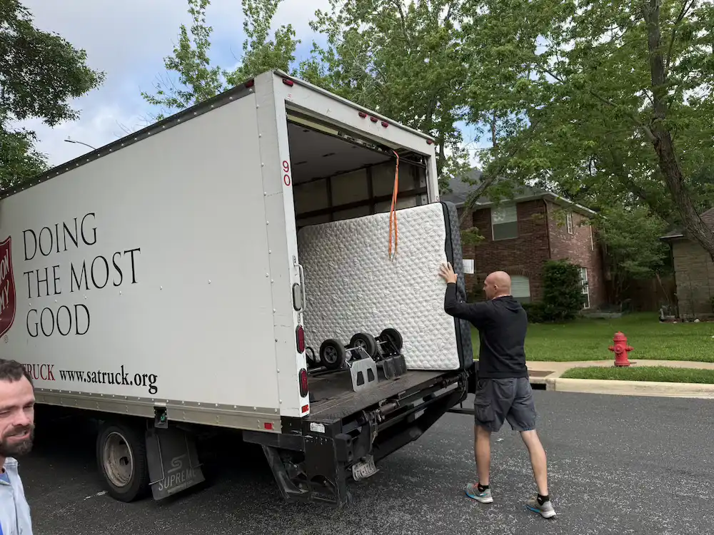 Mattress being loaded into a Salvation Army donation truck during a scheduled pickup