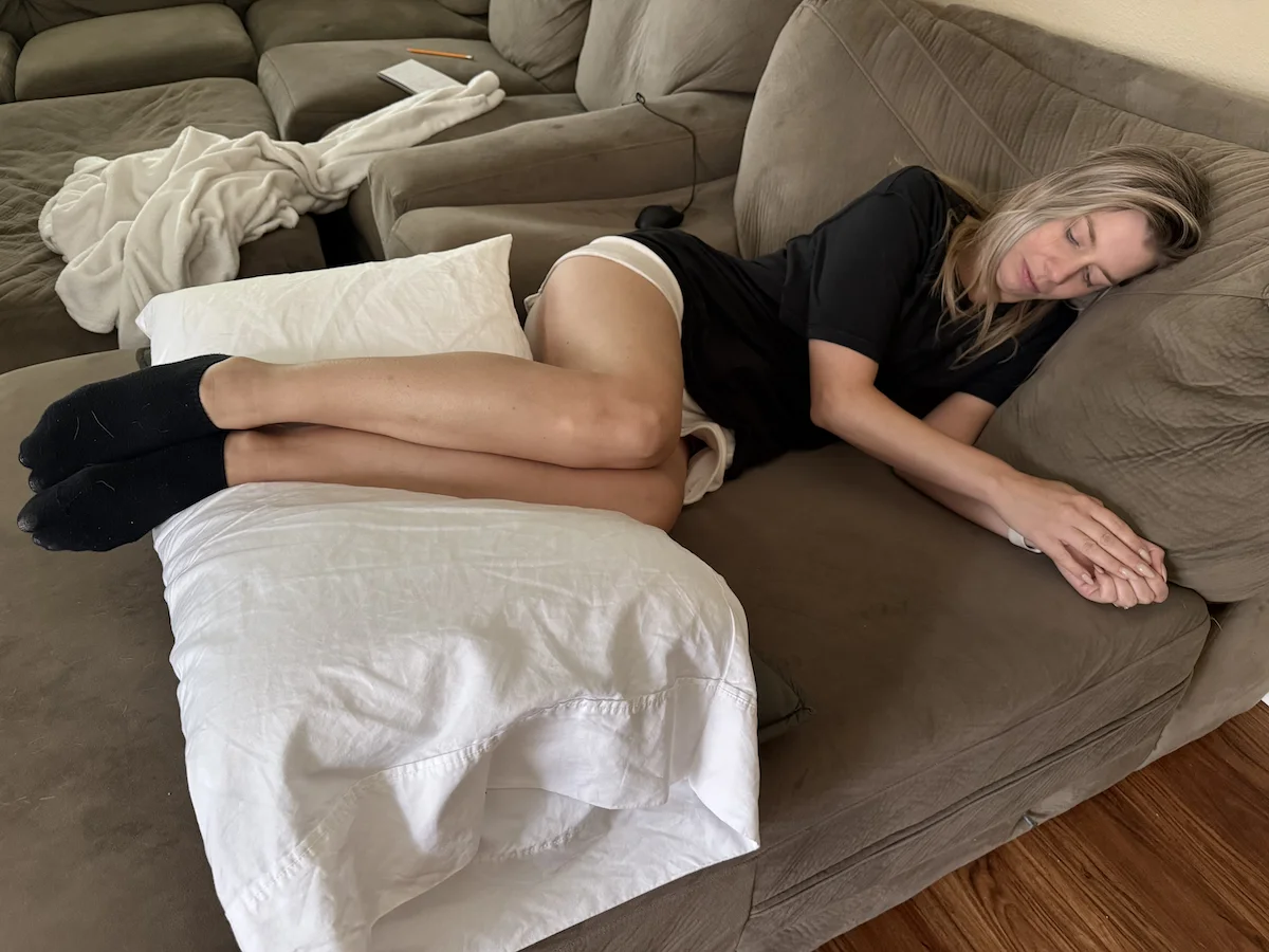 Side sleeper using a pillow between the knees and lower legs for support and alignment