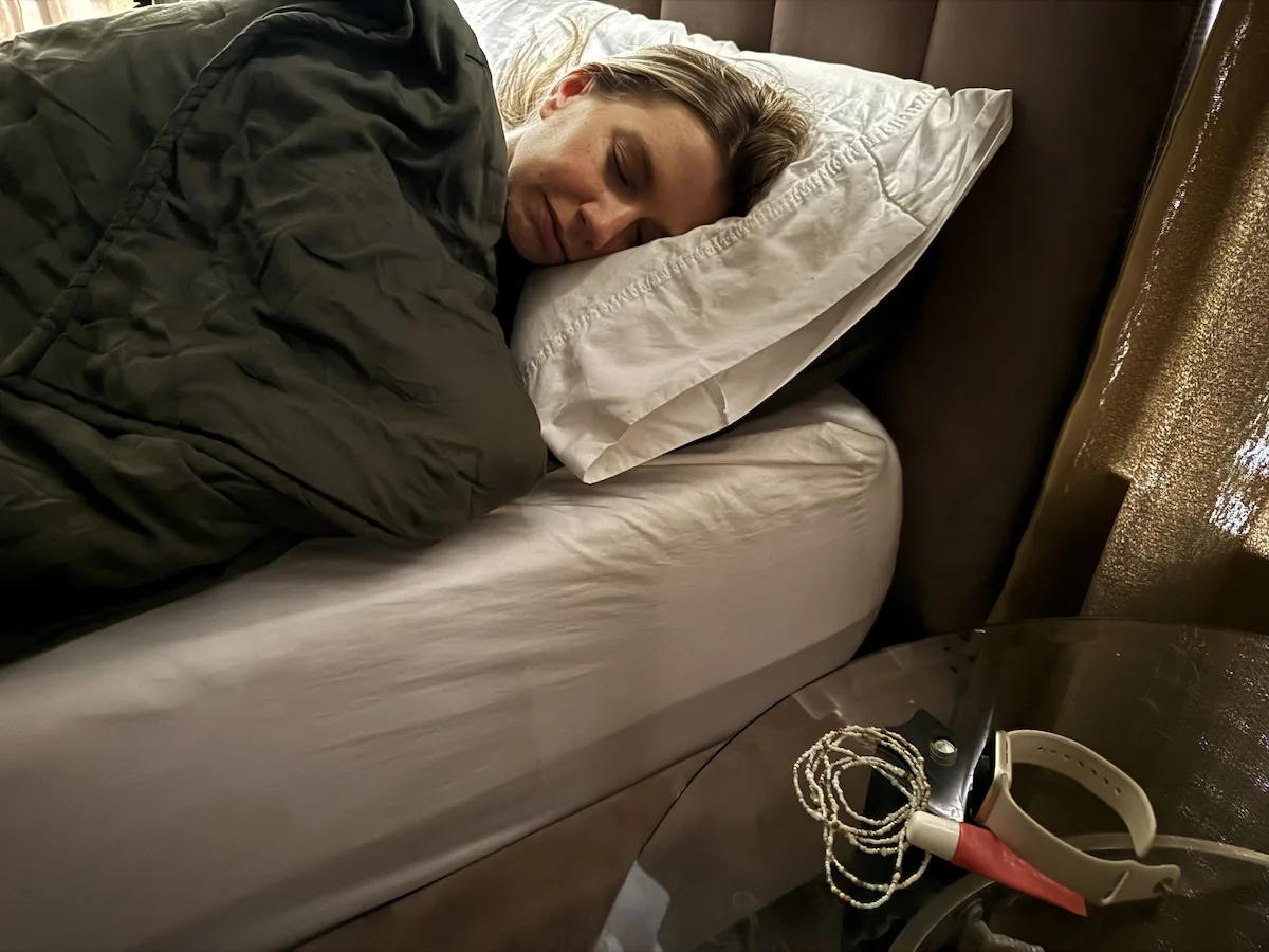 A woman sleeping next to a sleep tracking device - used to monitor sleep patterns and circadian rhythm habits.