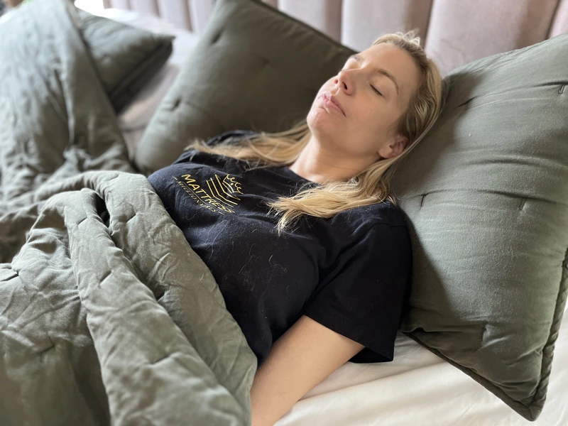 Person sleeping on their back with the upper body elevated to help reduce acid reflux symptoms.