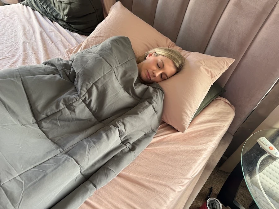 Image of a woman sleeping with a weighted blanket on her.
