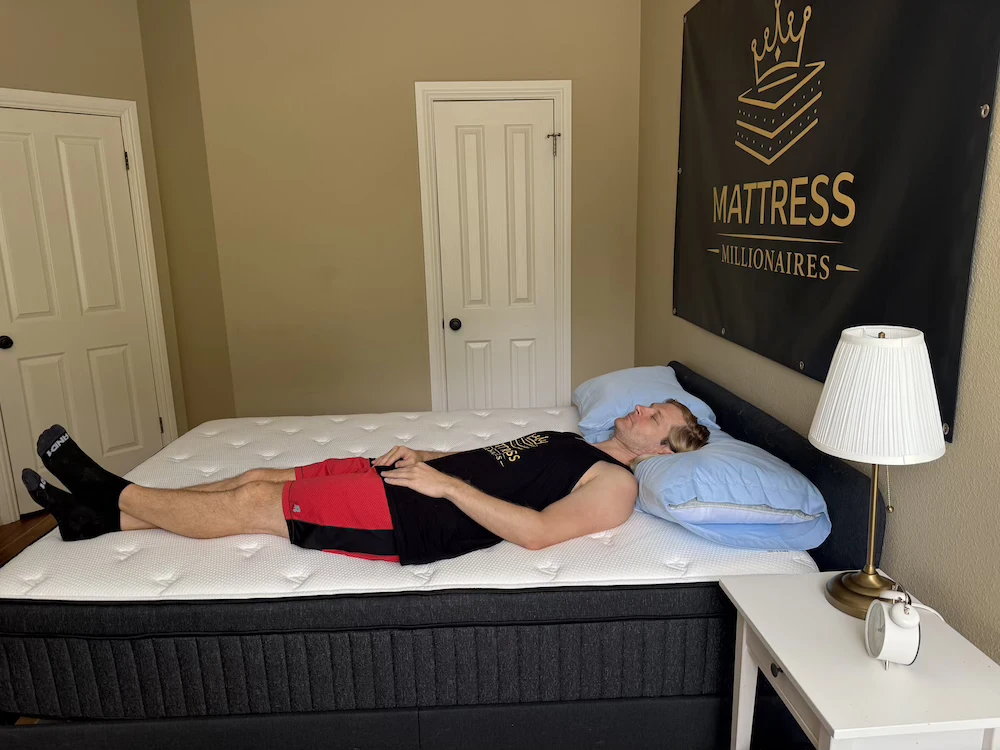 Tester lying on their back on the Titan Plus Luxe mattress during a comfort assessment.
